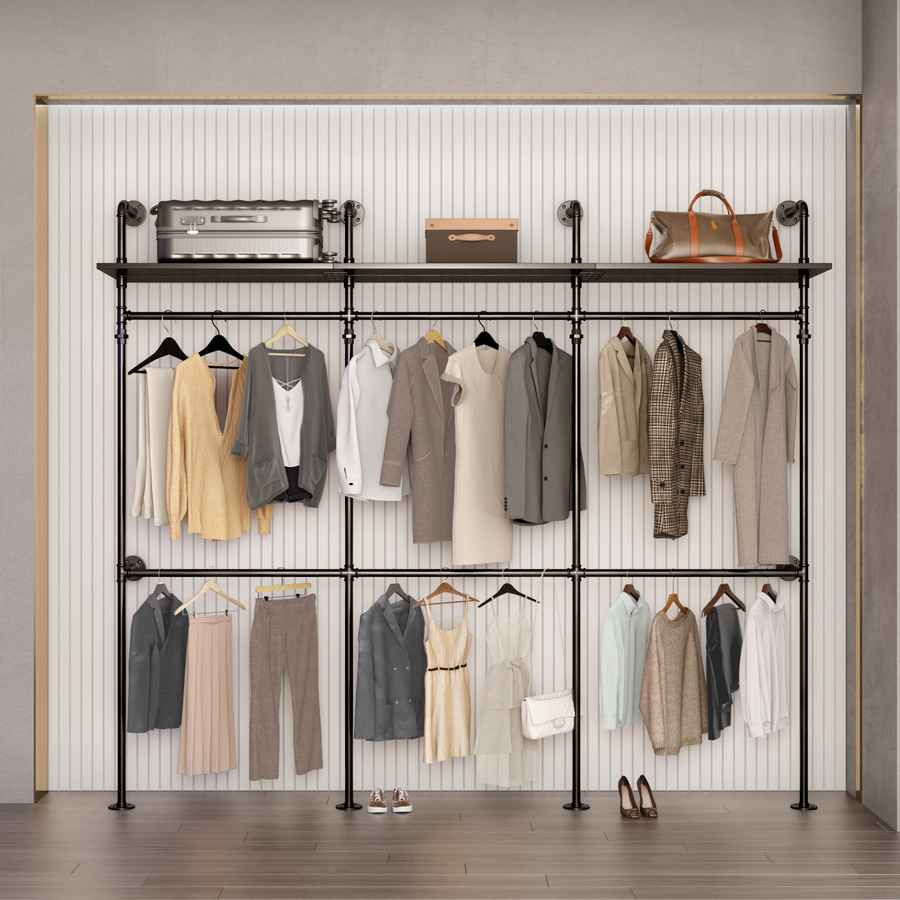 Industrial clothes rack with LED lights supporting hanging clothes in neutral tones, black metal frame, on a wooden floor with gray wall background