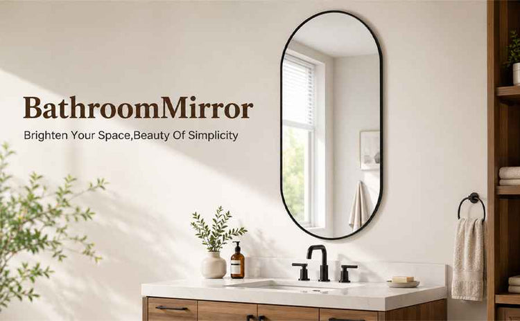 An oval bathroom mirror with a thin black frame hangs on a beige wall above a white and wood vanity. The mirror reflects a bright window, and the scene includes the text &
