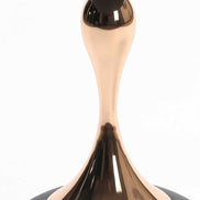 Close-up of the gold mermaid tail-inspired stem of the Modern Metal Coffee Table. Sculptural metal base adds elegance to any space.