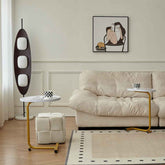 Modern living room with beige sofa, side table, and decorative elements.