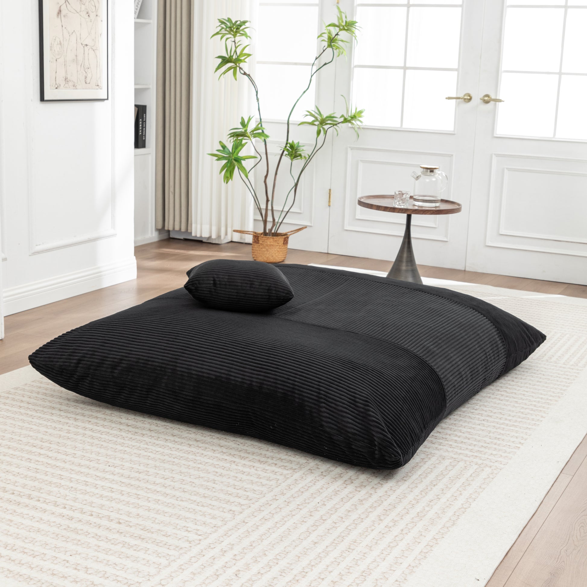 Black Corduroy Bean Bag Chair laid out flat with pillow, highlighting its soft texture and modern floor seating style.