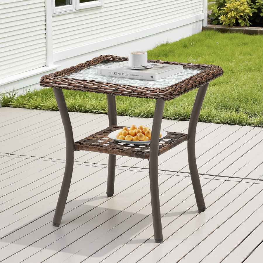 Hexagonal outdoor side table with a glass top and wicker sides on a wooden deck.