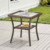 Hexagonal outdoor side table with a glass top and wicker sides on a wooden deck.