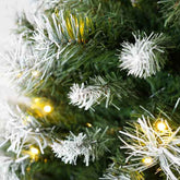 Decorative Christmas tree with white snowflake ornaments and yellow lights.