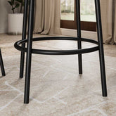 Detail view of the black metal footrest and legs from the 3-Piece Bar Table Set with 2 Stools, emphasizing its sturdy build and modern style.