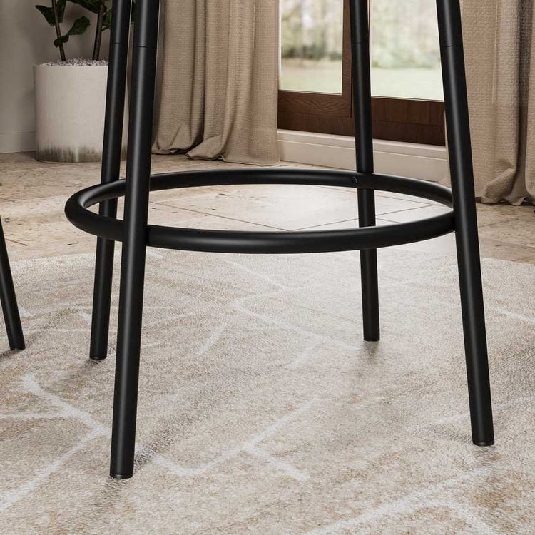 Detail view of the black metal footrest and legs from the 3-Piece Bar Table Set with 2 Stools, emphasizing its sturdy build and modern style.