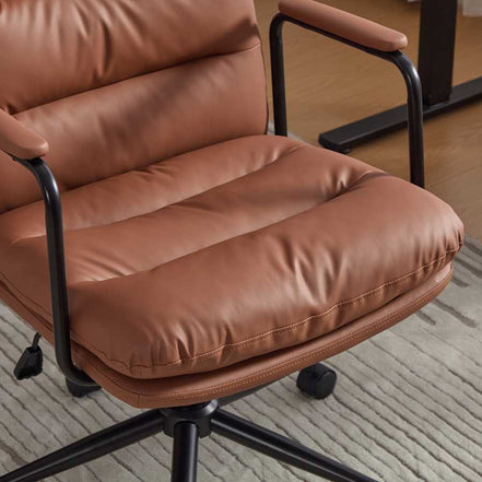 Close-up of seat cushion on brown ergonomic office chair with thick padding and soft leather finish. Designed for extended sitting comfort.