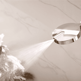 Shower head with water spray on a neutral background
