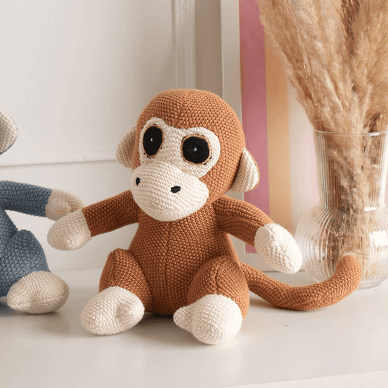 Cute knitted monkey plush toy on display