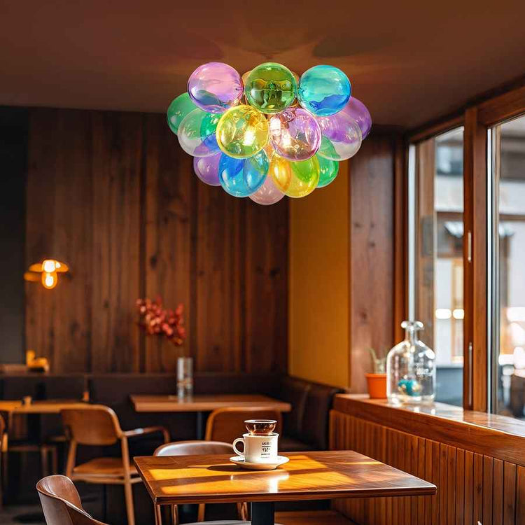 Colorful balloon chandelier in a restaurant setting with wooden tables and chairs.