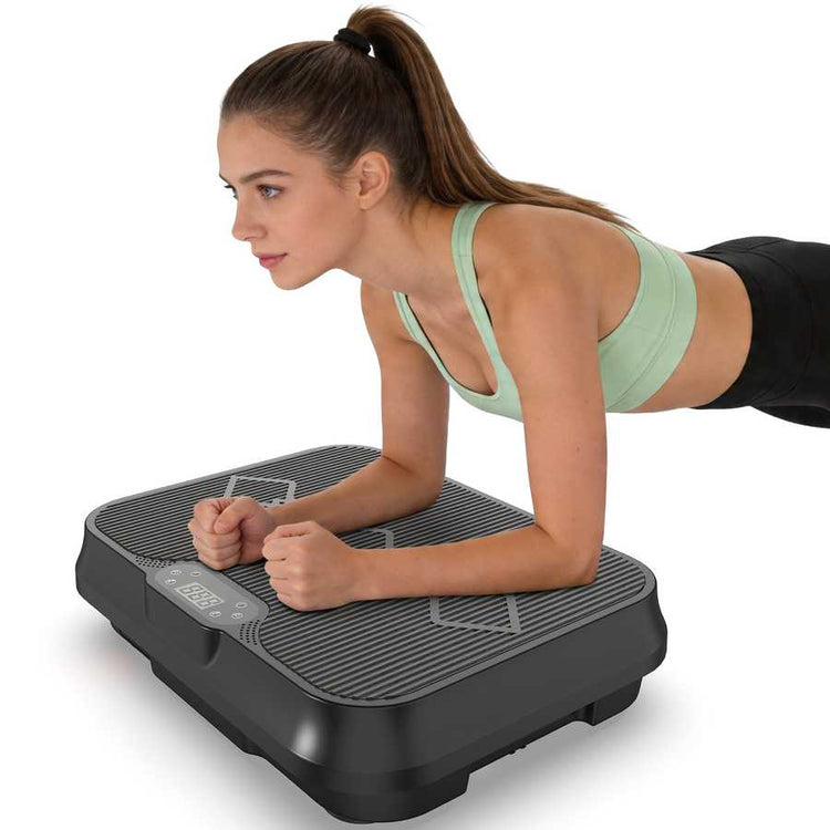 Woman in workout pose on vibration exercise machine