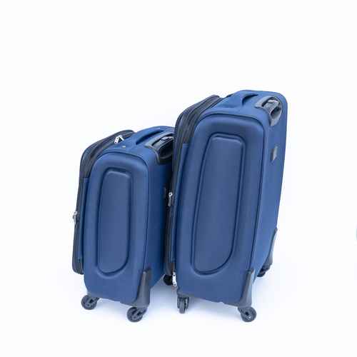 Blue rolling suitcase with ergonomic handle and four spinner wheels, designed for easy maneuverability during travel.