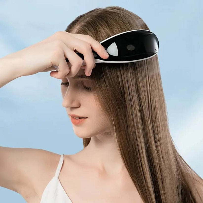 Woman using electric scalp massager comb for relaxation