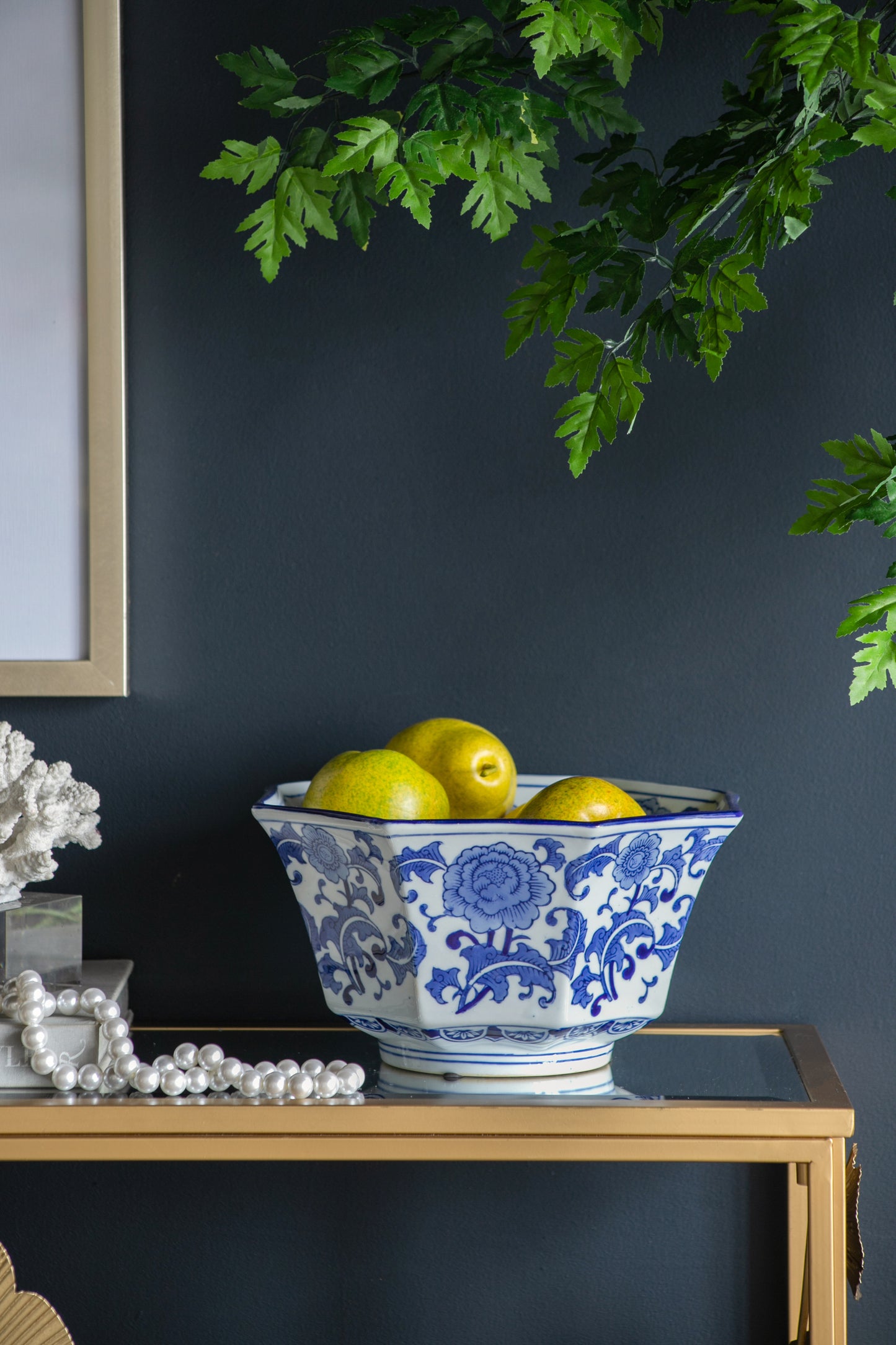 Blue and White Decorative Bowl - Porcelain, Elegant Design used as a fruit bowl on a gold table, enhancing dark wall decor.