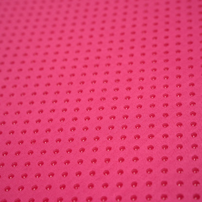 Close-up of anti-slip dotted base on pink ergonomic memory foam posture support pillow for enhanced grip and stability.