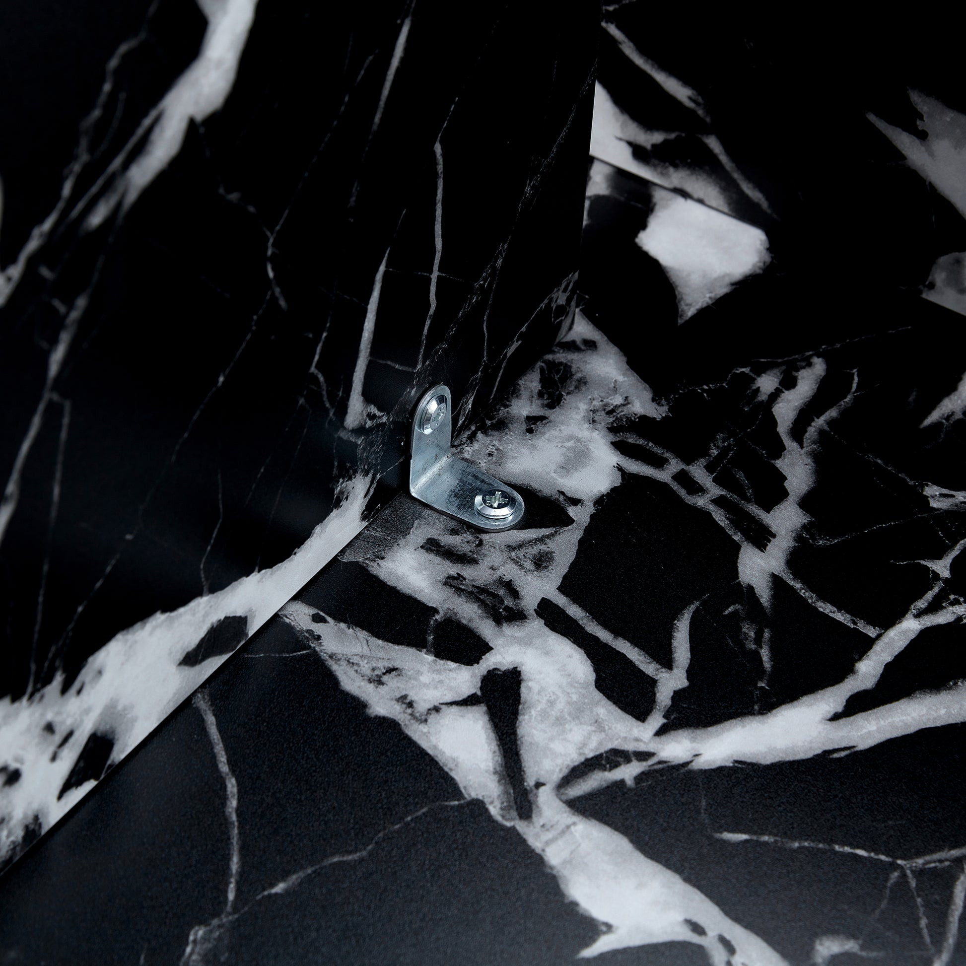 Interior bracket of black MDF round coffee table with modern minimalism, showing secure metal hardware for stability.