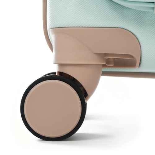 Close-up of a hard-shell suitcase wheel and base, showing a pale mint green textured shell, beige plastic trim and hub, and a black wheel rim on a white background.