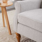 Gray upholstered chair with wooden legs in a room setting