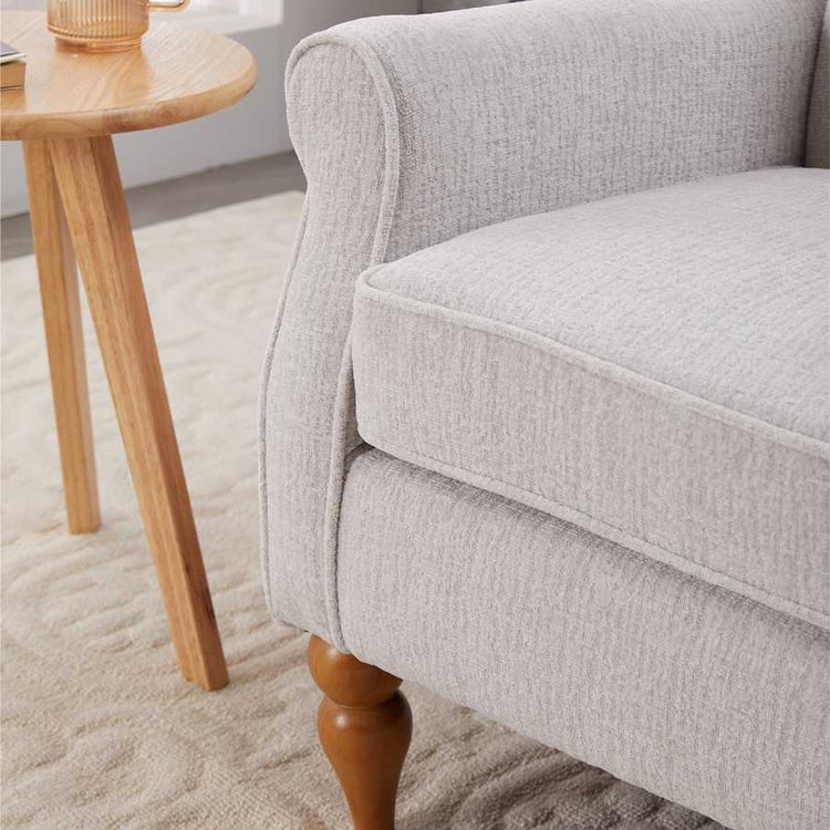 Gray upholstered chair with wooden legs in a room setting