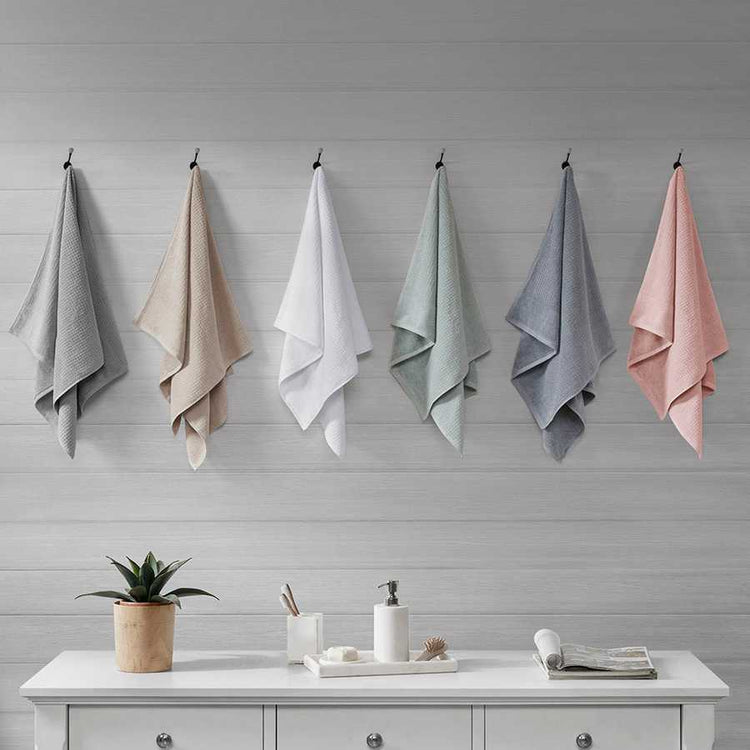 Cotton Antimicrobial Bath Towels in six colors hanging on hooks, ideal for quick-dry use in modern home and garden bathrooms.