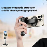 A hand holds a black magnetic phone tripod attachment against a blurred outdoor background, with a smartphone mounted on the device. Text at the top reads &