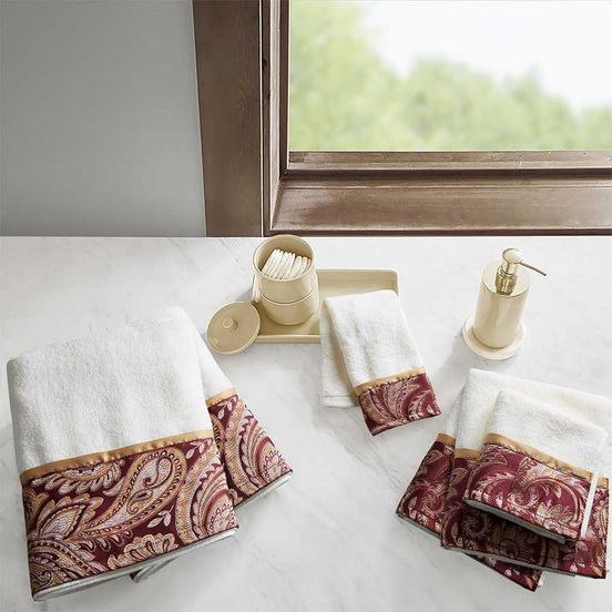 6 Piece Jacquard Towel Set in burgundy with paisley border, displayed in an elegant bathroom setting. Made of 100% cotton and machine washable.