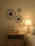 Elegant metal wall art for home decoration set of 3 sunflower designs above a nightstand with lamp. Adds rustic charm to bedroom decor.