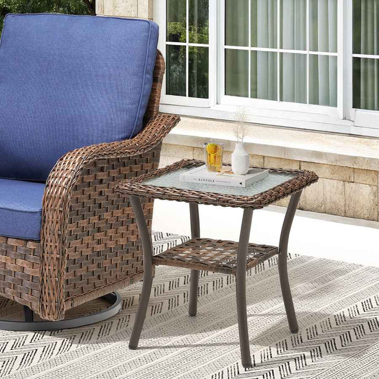 Wicker chair with blue cushion and matching side table on a patio