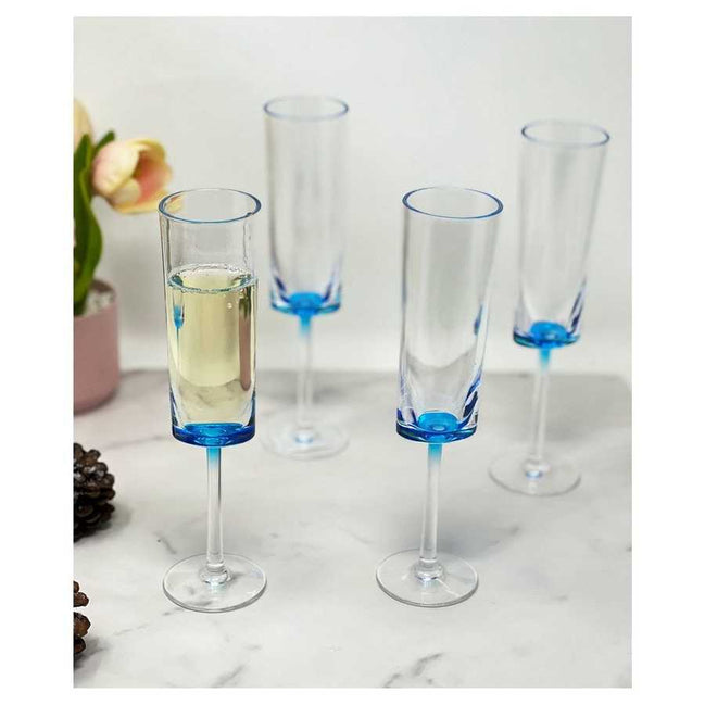 Unbreakable Champagne Flutes Set of 4 in blue acrylic, displayed on a marble surface with one filled with champagne, ideal for parties.