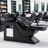 Salon workspace with black chairs and shelves of hair products