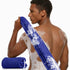 Man with a blue towel and soapy back on a white background