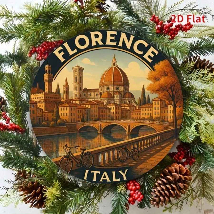 A round decorative sign featuring an illustrated scene of Florence, Italy, with the dome of the cathedral, bridge, river, and bicycles. The sign is surrounded by a festive wreath of pine branches, red berries, and pinecones, with the words &