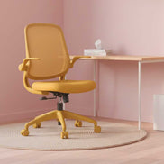 Yellow office chair in a room with a pink wall and wooden desk.