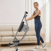 Woman exercising on a home fitness machine in a living room.