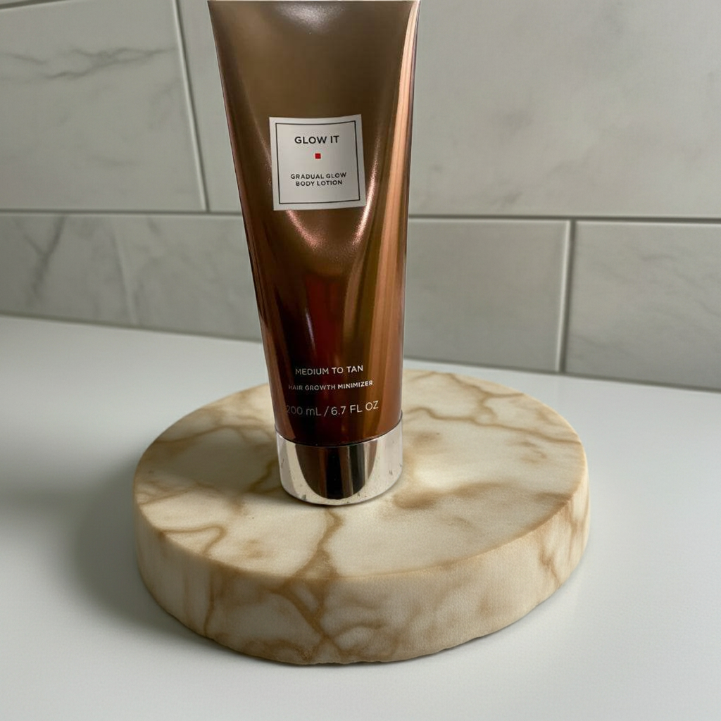 Glow It Gradual Glow Body Lotion Medium to Tan 6.7 fl oz displayed on marble tray, perfect for enhancing natural tan and skin hydration.
