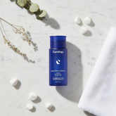 Liquid Pore Exfoliant lifestyle flat lay on cool marble with white pebbles and botanicals