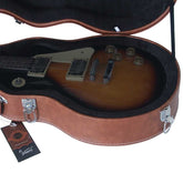 Electric guitar in an open brown case with a visible brand tag.