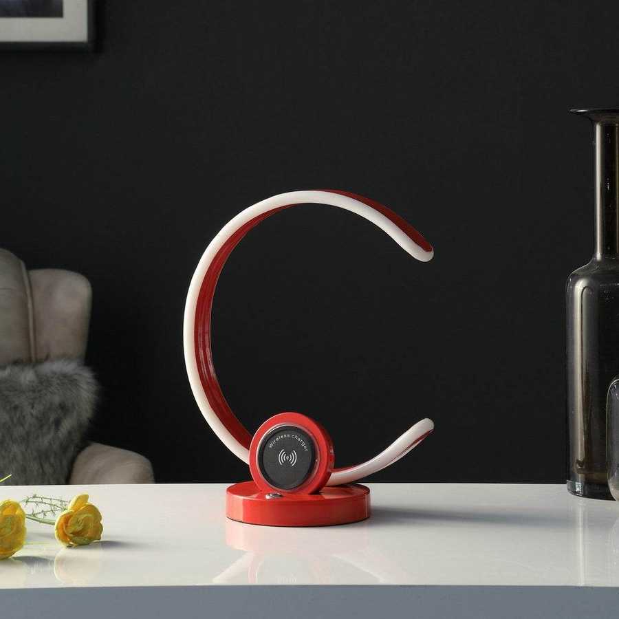Red and white electronic device on a table with a dark background