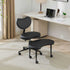 Black ergonomic chair in a home office setting with a desk and lamp.